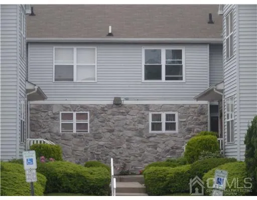 a brick house with yard and parking space
