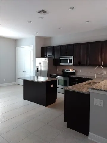 a kitchen with stainless steel appliances granite countertop a stove a sink and a microwave