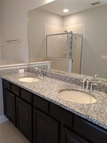 a bathroom with a granite countertop sink double and mirror
