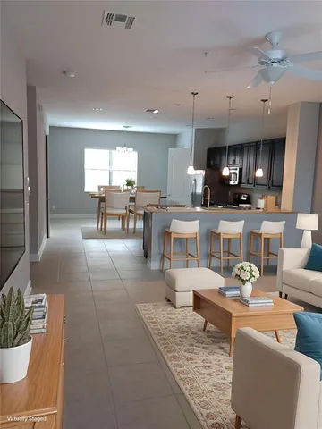 a living room with furniture and a dining table with kitchen view