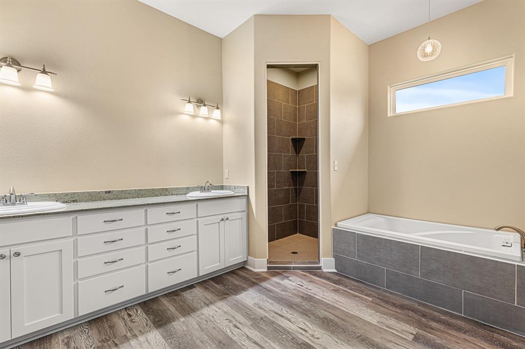 10160 Wallace Road Holland, TX 76534 - Photo 16 of 40 Bathroom featuring a garden tub, a stall shower, double vanity, and light wood-type flooring