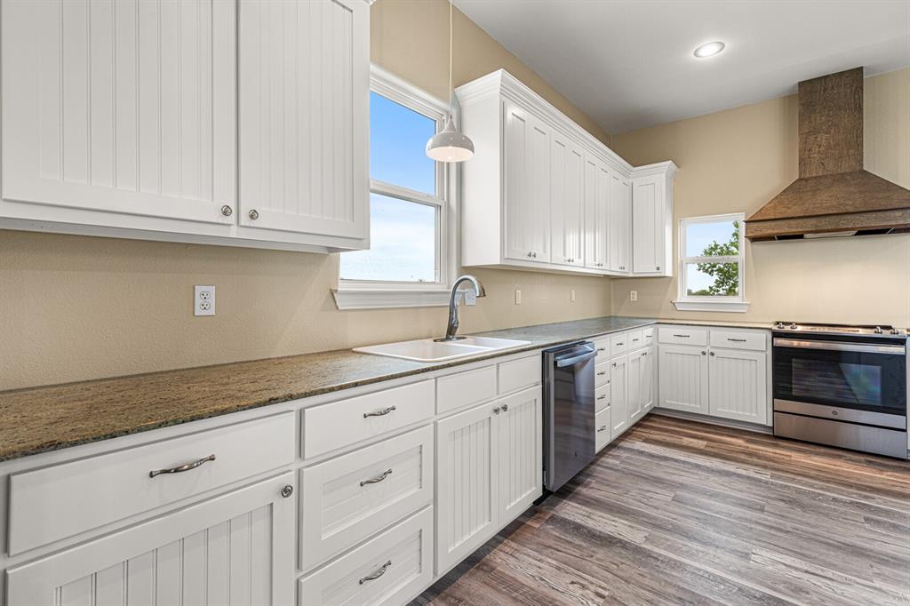 10160 Wallace Road Holland, TX 76534 - Photo 27 of 40 Kitchen with wall chimney range hood, appliances with stainless steel finishes, white cabinets, dark wood-style flooring, and recessed lighting