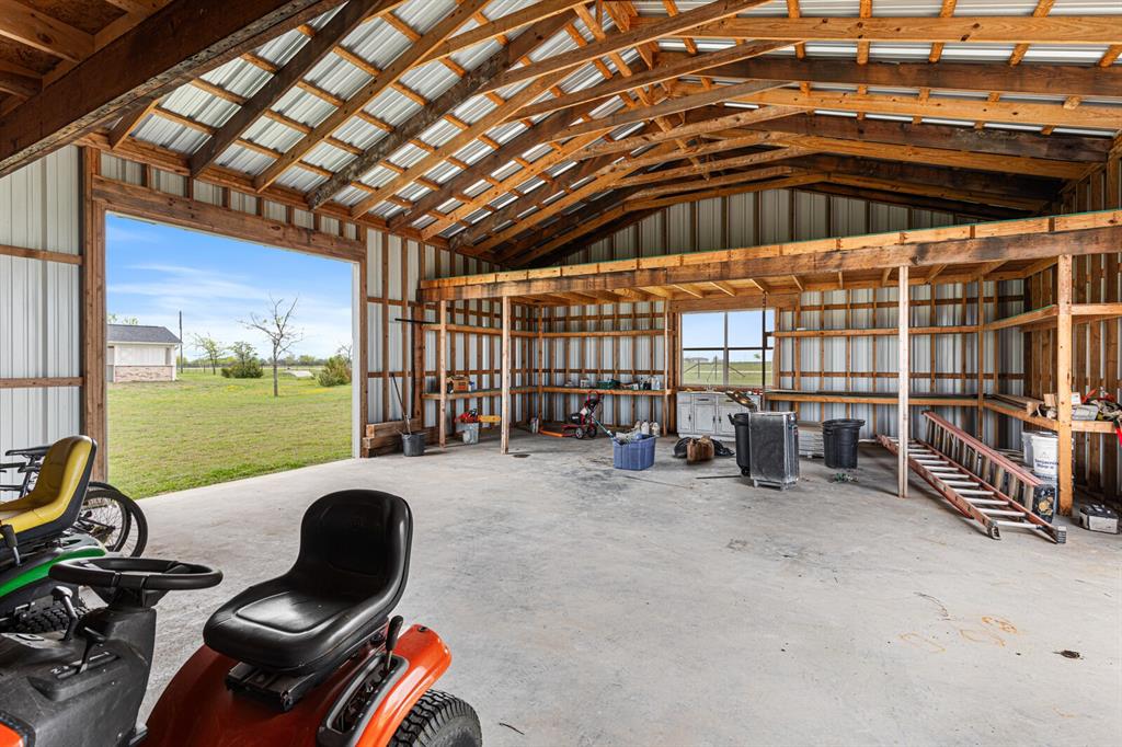 10160 Wallace Road Holland, TX 76534 - Photo 39 of 40 Misc room with unfinished concrete flooring, metal wall, and high vaulted ceiling