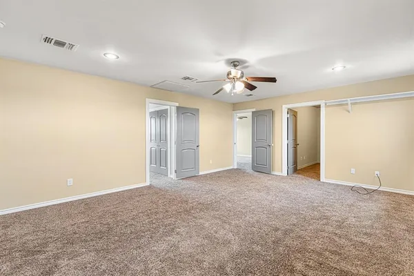 a view of an empty room with a ceiling fan