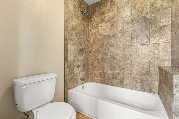 a white toilet sitting next to a bathtub