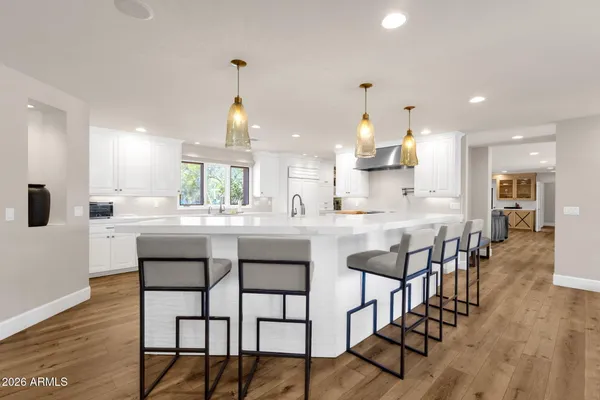 a kitchen with stainless steel appliances kitchen island granite countertop a dining table chairs and sink