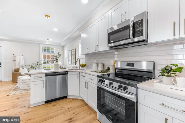 a kitchen with stainless steel appliances white cabinets granite counter tops and a stove top oven