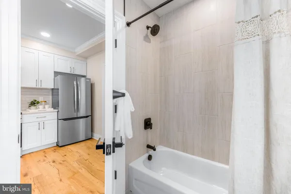 a bathroom with a tub sink shower and mirror
