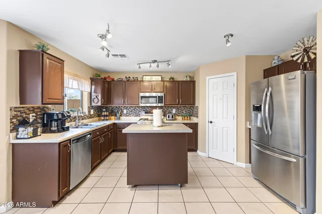 a kitchen with stainless steel appliances granite countertop a refrigerator and a sink