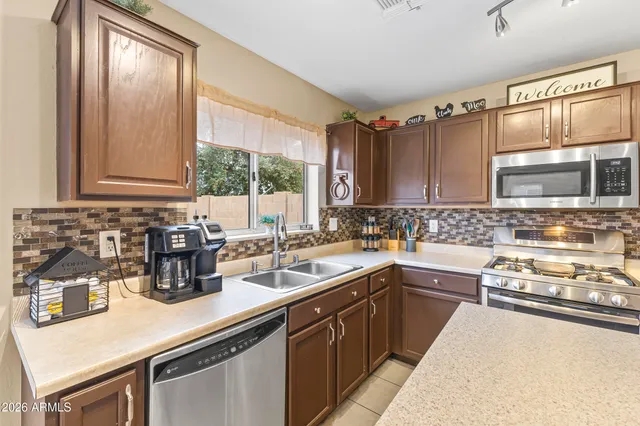 a kitchen with stainless steel appliances granite countertop a sink stove and cabinets