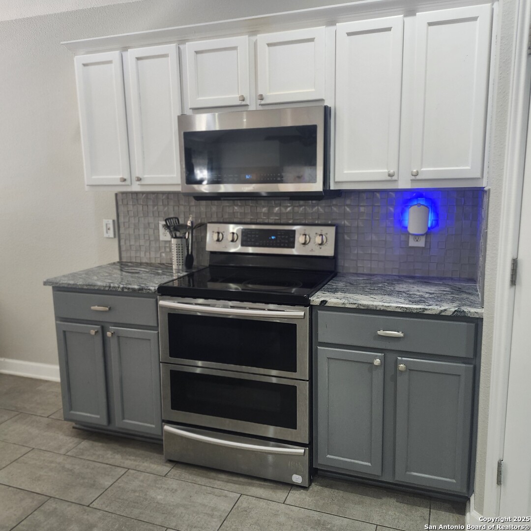 9402 Anderson Way Converse, TX 78109 - Photo 13 of 37 a kitchen with granite countertop white cabinets and stainless steel appliances
