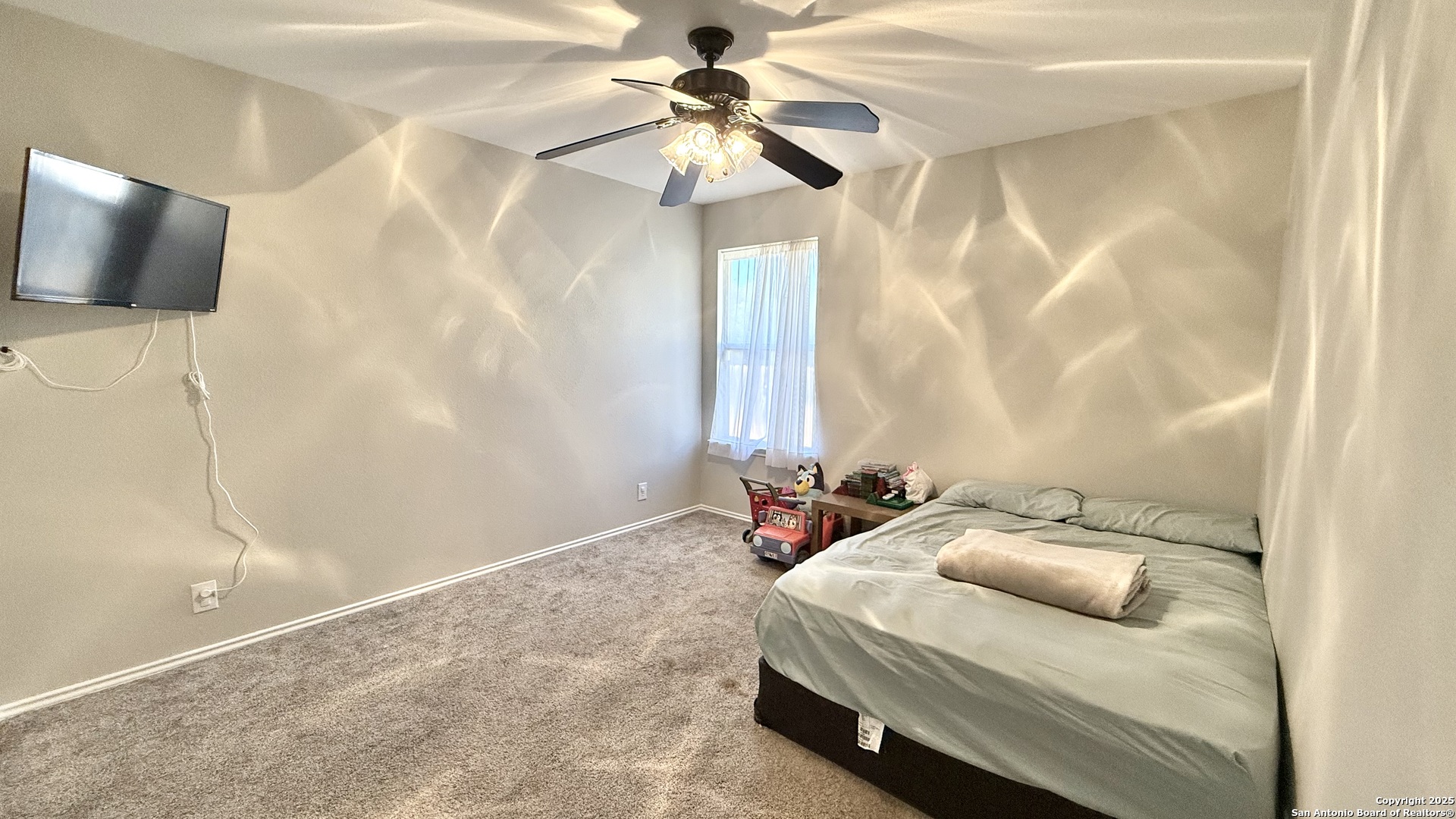 9402 Anderson Way Converse, TX 78109 - Photo 16 of 37 a bedroom with a bed and a chandelier with a flat tv screen