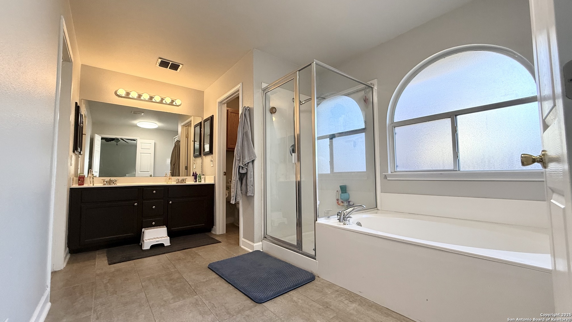 9402 Anderson Way Converse, TX 78109 - Photo 20 of 37 a spacious bathroom with a bathtub double sink and mirror