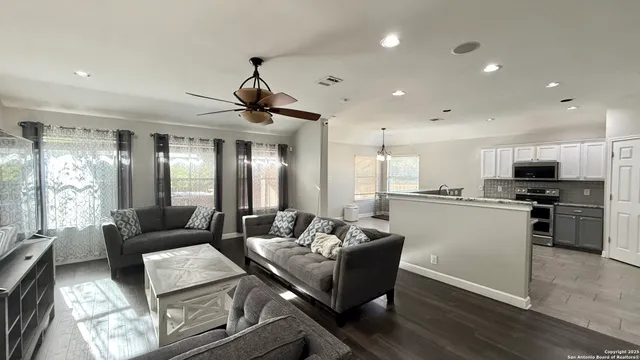 a kitchen with stainless steel appliances kitchen island granite countertop a sink and a refrigerator