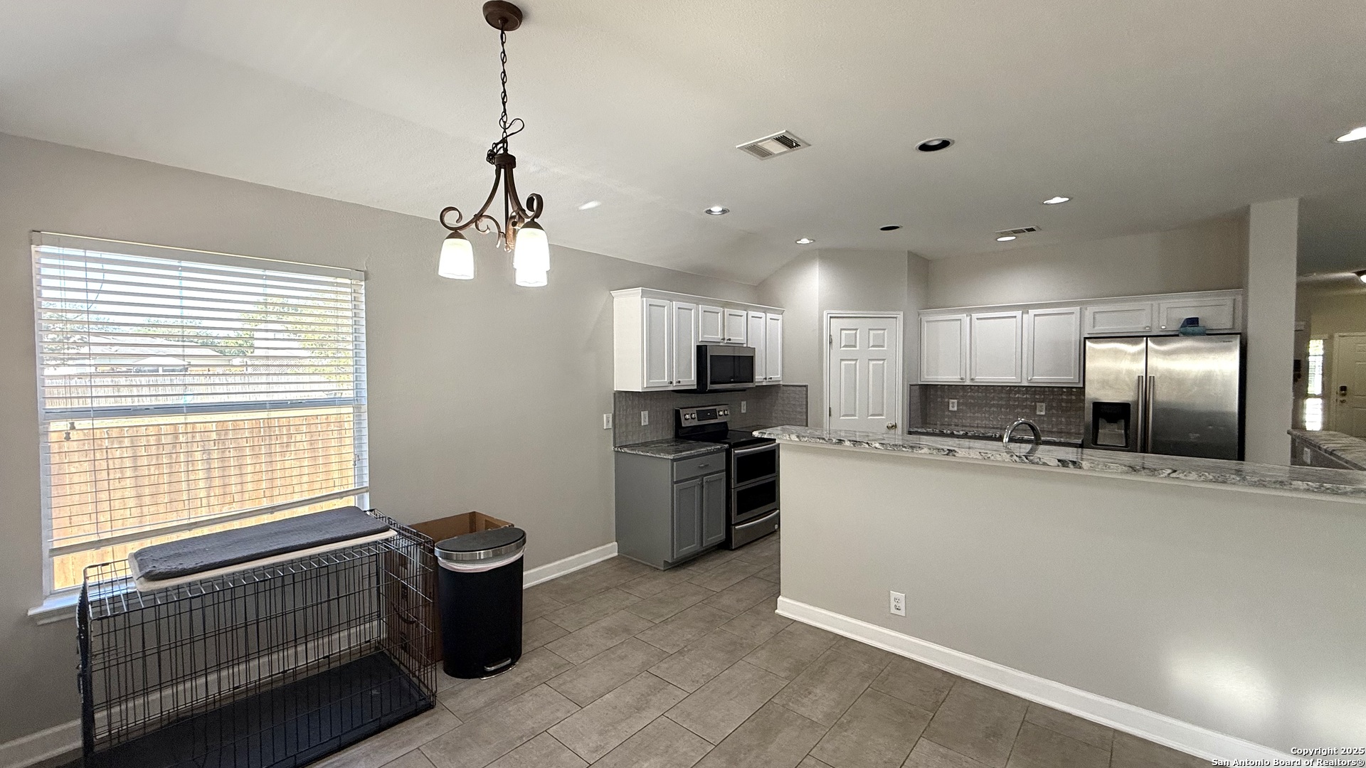 9402 Anderson Way Converse, TX 78109 - Photo 5 of 37 a kitchen with stainless steel appliances kitchen island granite countertop a sink and a refrigerator