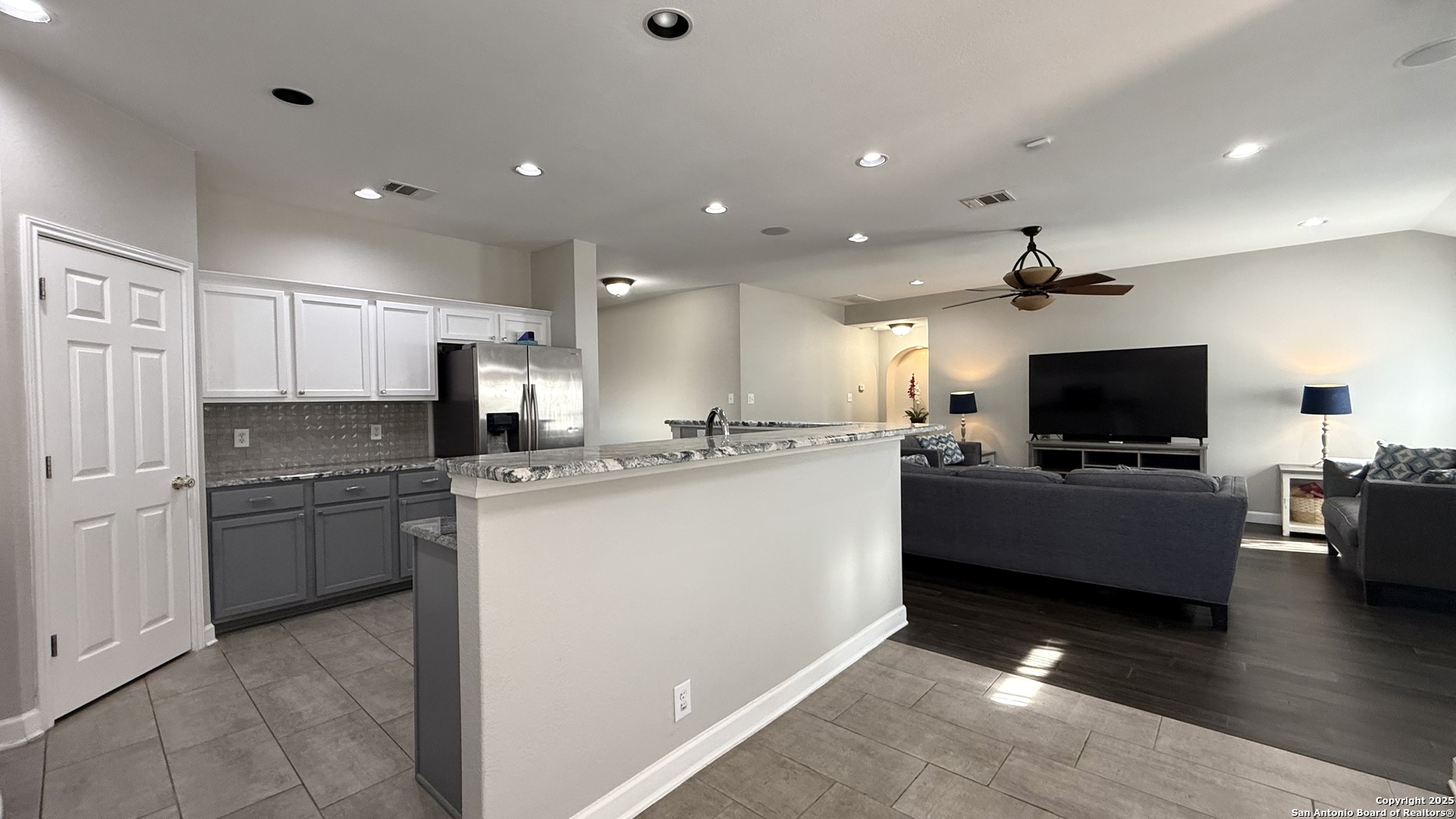 9402 Anderson Way Converse, TX 78109 - Photo 10 of 37 a kitchen with stainless steel appliances kitchen island granite countertop a refrigerator oven a sink dishwasher a dining table and chairs with wooden floor