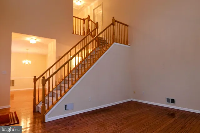a view of staircase with wooden floor and white walls