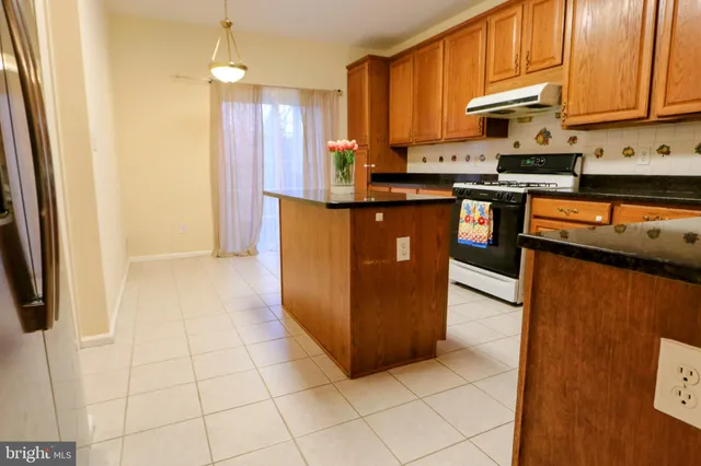 a kitchen with stainless steel appliances granite countertop a stove a refrigerator and a microwave