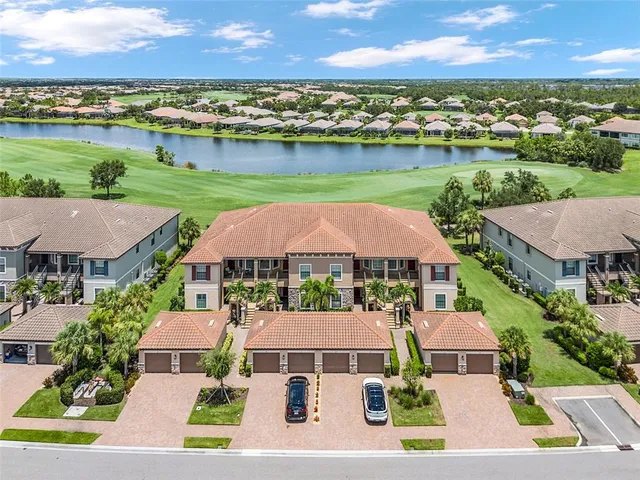 an aerial view of a house with a garden and lake view