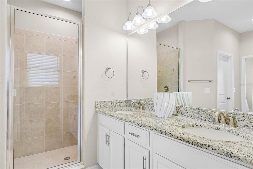 13725 Messina Loop, Unit 201 Bradenton, FL 34211 - Photo 16 of 39 a bathroom with a granite countertop double vanity sink a mirror and shower
