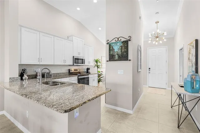 a kitchen with stainless steel appliances granite countertop a sink dishwasher and a refrigerator with wooden floor