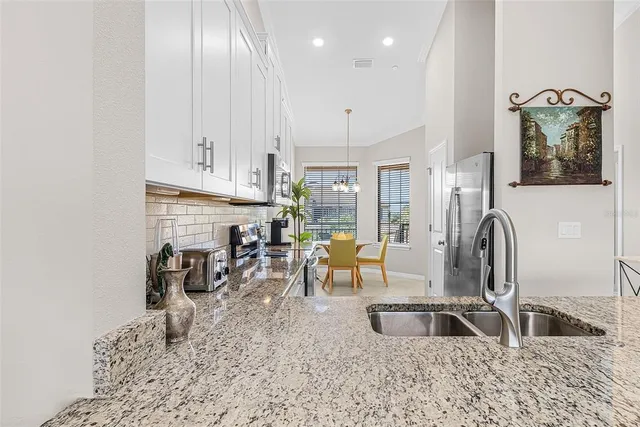 a view of a kitchen with kitchen island granite countertop a sink and a wooden floors