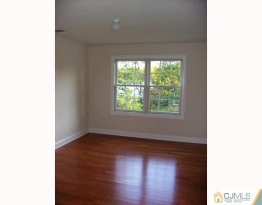 331 Chain O' Hills Road Colonia, NJ 07067 - Photo 5 of 8 a view of an empty room with wooden floor and a window