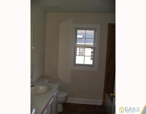 331 Chain O' Hills Road Colonia, NJ 07067 - Photo 6 of 8 a bathroom with a toilet a sink and a window
