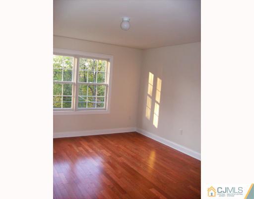331 Chain O' Hills Road Colonia, NJ 07067 - Photo 7 of 8 a view of an empty room with wooden floor and a window