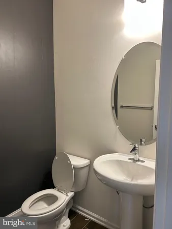 a bathroom with a toilet a sink and mirror