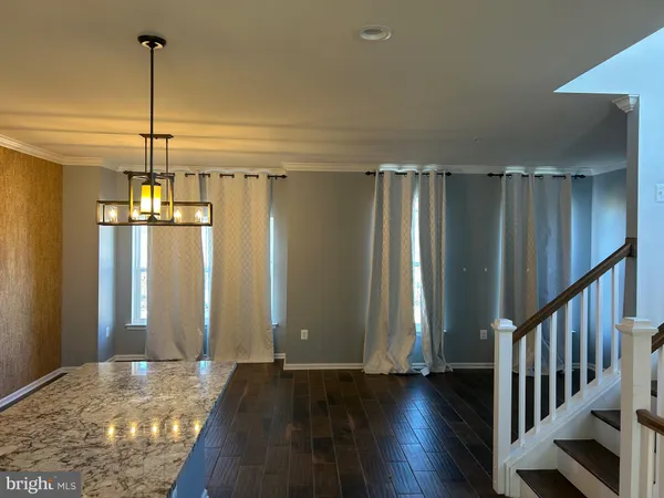 a view of a hallway with wooden floor and stairs