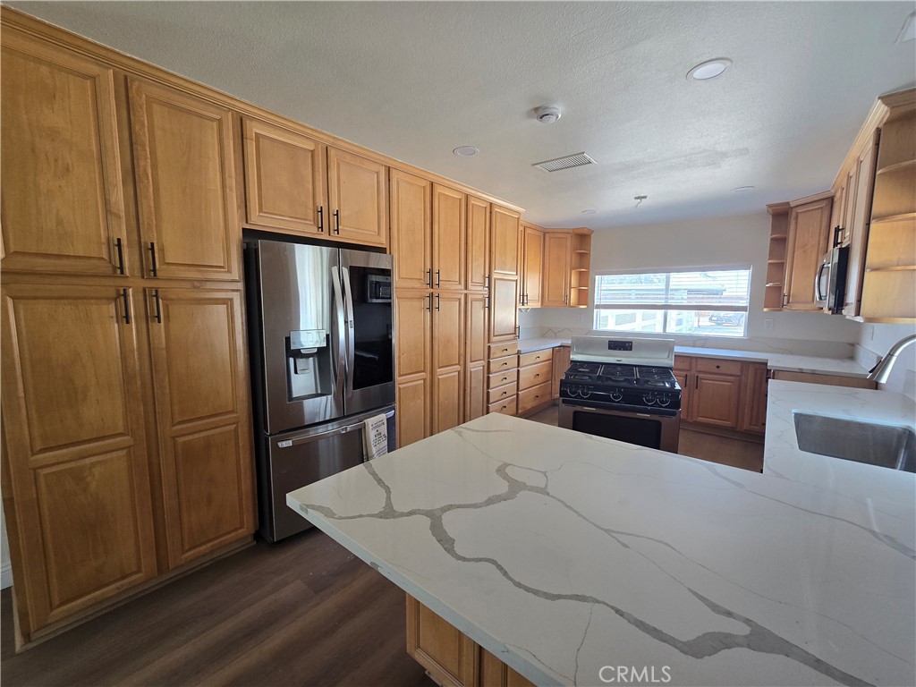 876 River Drive Norco, CA 92860 - Photo 12 of 22 a kitchen with stainless steel appliances a refrigerator and wooden cabinets
