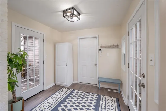 a view of a hallway with wooden floor and a livingroom