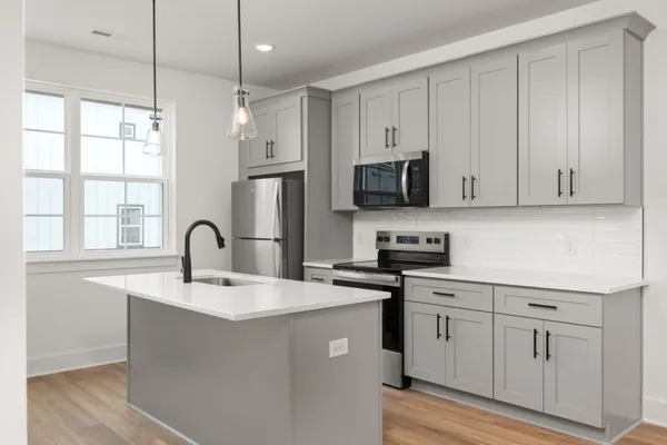 a kitchen with stainless steel appliances granite countertop a sink a stove a refrigerator and cabinets