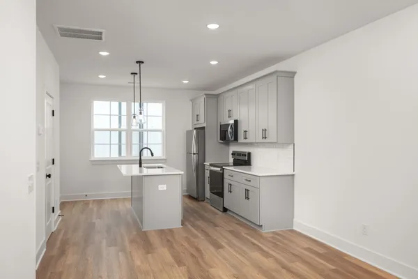 a kitchen with cabinets a sink and wooden floor