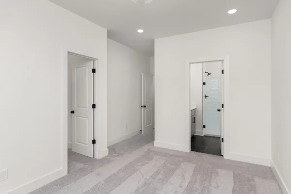 a view of an empty room with wooden floor and closet