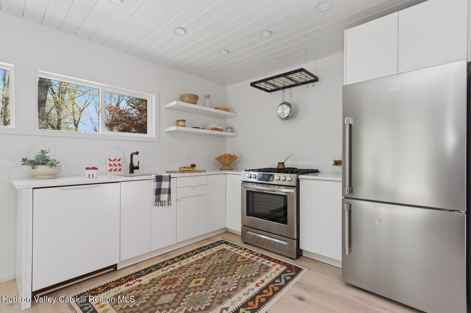 25 Upper Cherrytown Road Kerhonkson, NY 12446 - Photo 11 of 23 a kitchen with stainless steel appliances a refrigerator and a stove top oven