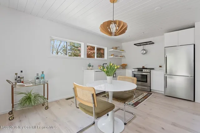 a view of a dining room with furniture a chandelier and wooden floor