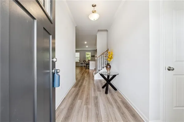 a view of a hallway with wooden floor and staircase