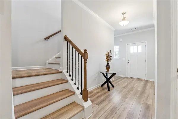 a view of a hallway with wooden floor and stairs
