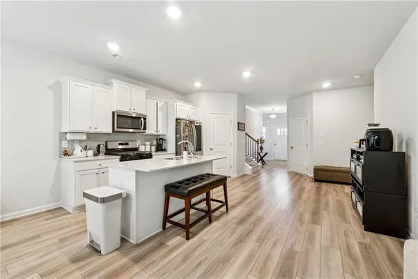 a kitchen with white cabinets and stainless steel appliances