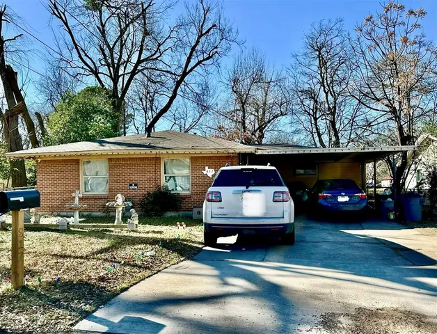 a car parked in front of a white house