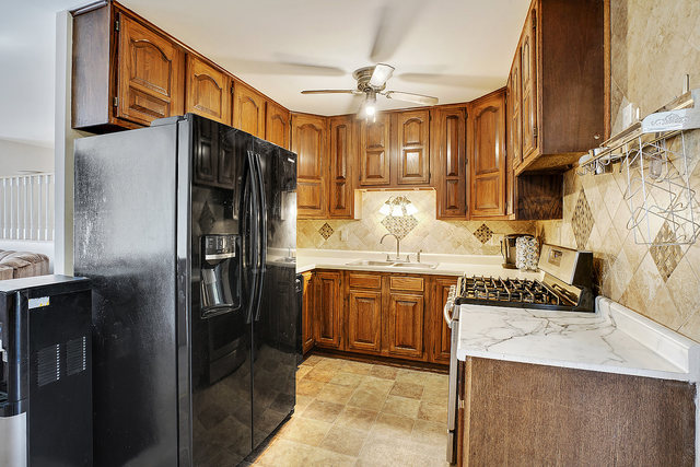 727 Delta Avenue Romeoville, IL 60446 - Photo 5 of 11 a kitchen with stainless steel appliances granite countertop a sink refrigerator and cabinets