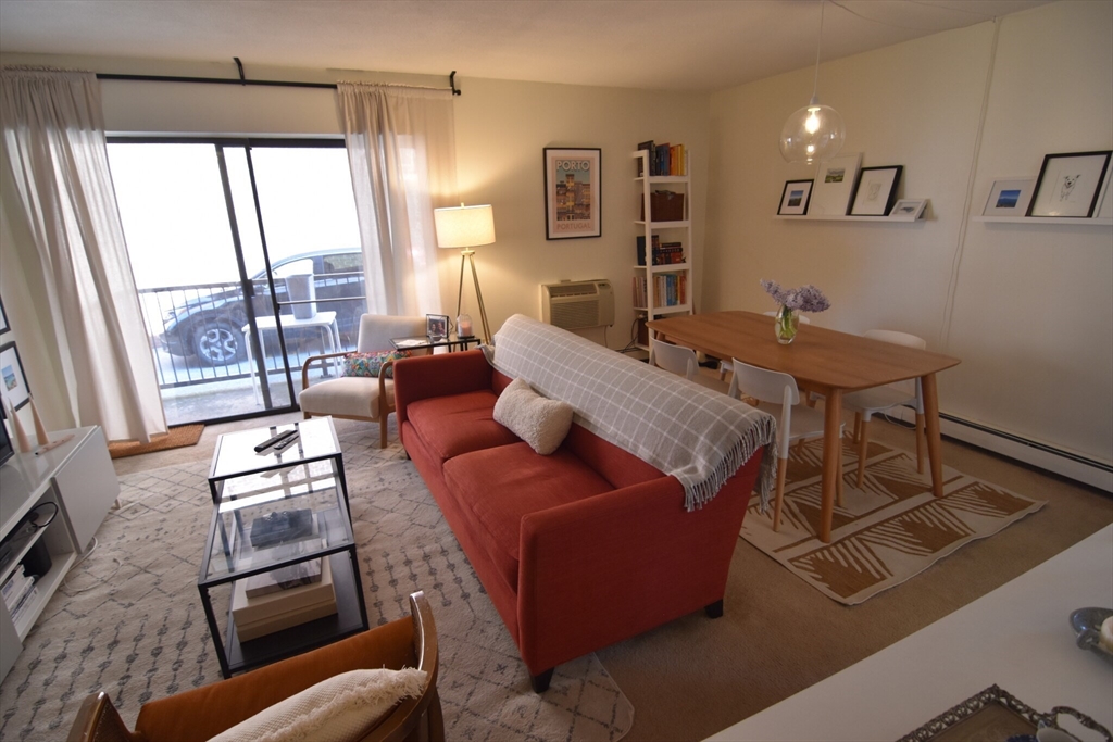 a living room with furniture and a floor to ceiling window