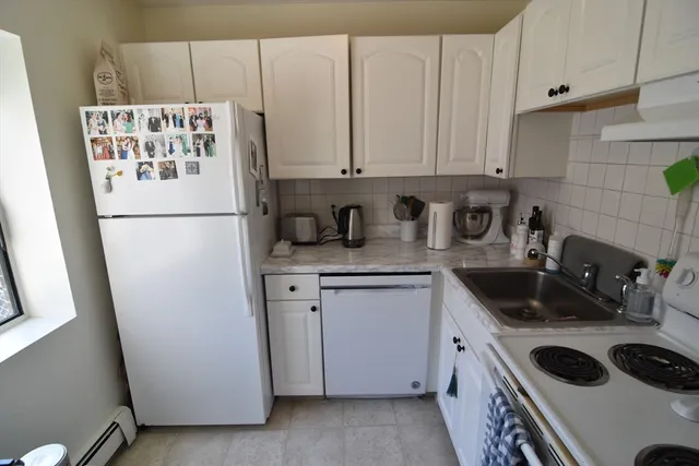 a kitchen with refrigerator a stove a sink and cabinets