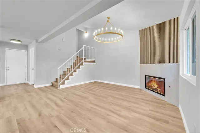 a view of a room with wooden floor and chandelier