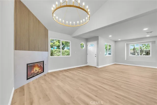 an empty room with windows and fireplace