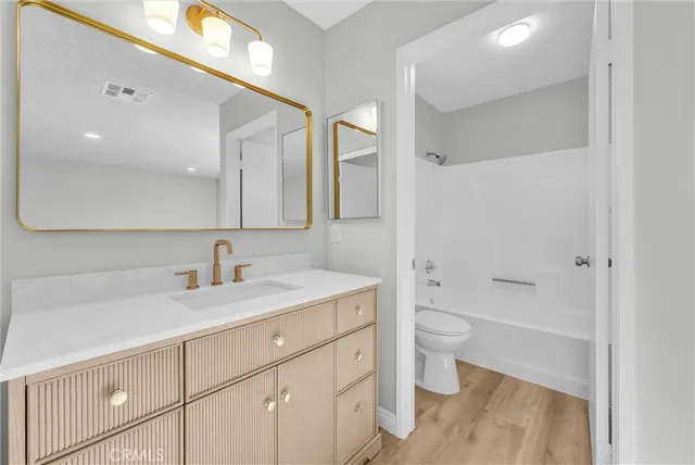 a bathroom with a sink a toilet a shower and a mirror