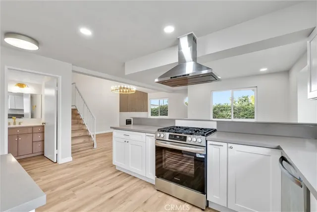a kitchen with stainless steel appliances a stove a sink and a refrigerator