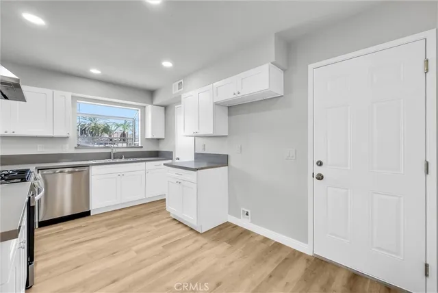 a kitchen with granite countertop white cabinets and white appliances